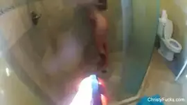 امرأة سمراء مفلس لديها متعة في الحمام.